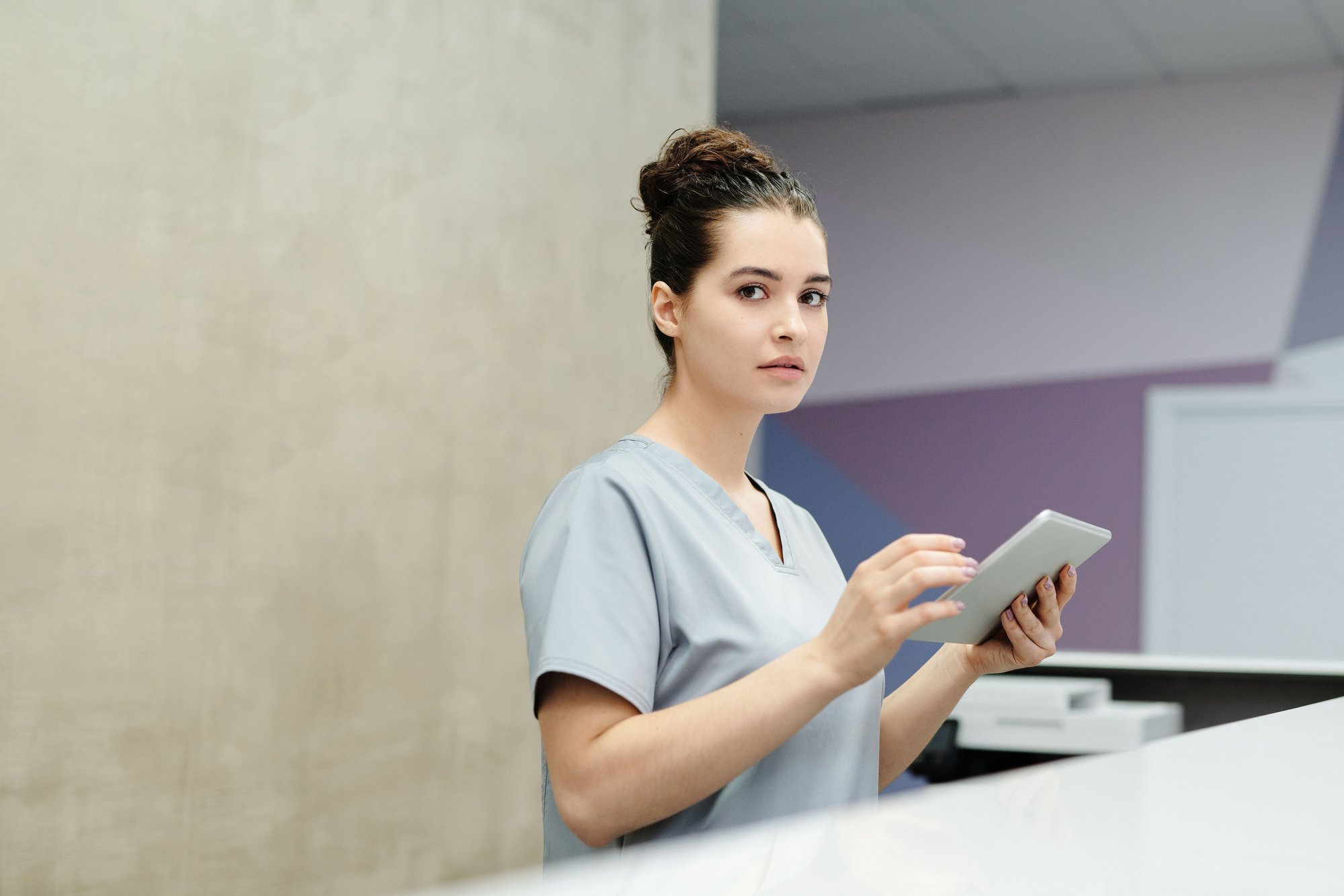 Recepcionista conferindo confirmação de presença em tablet