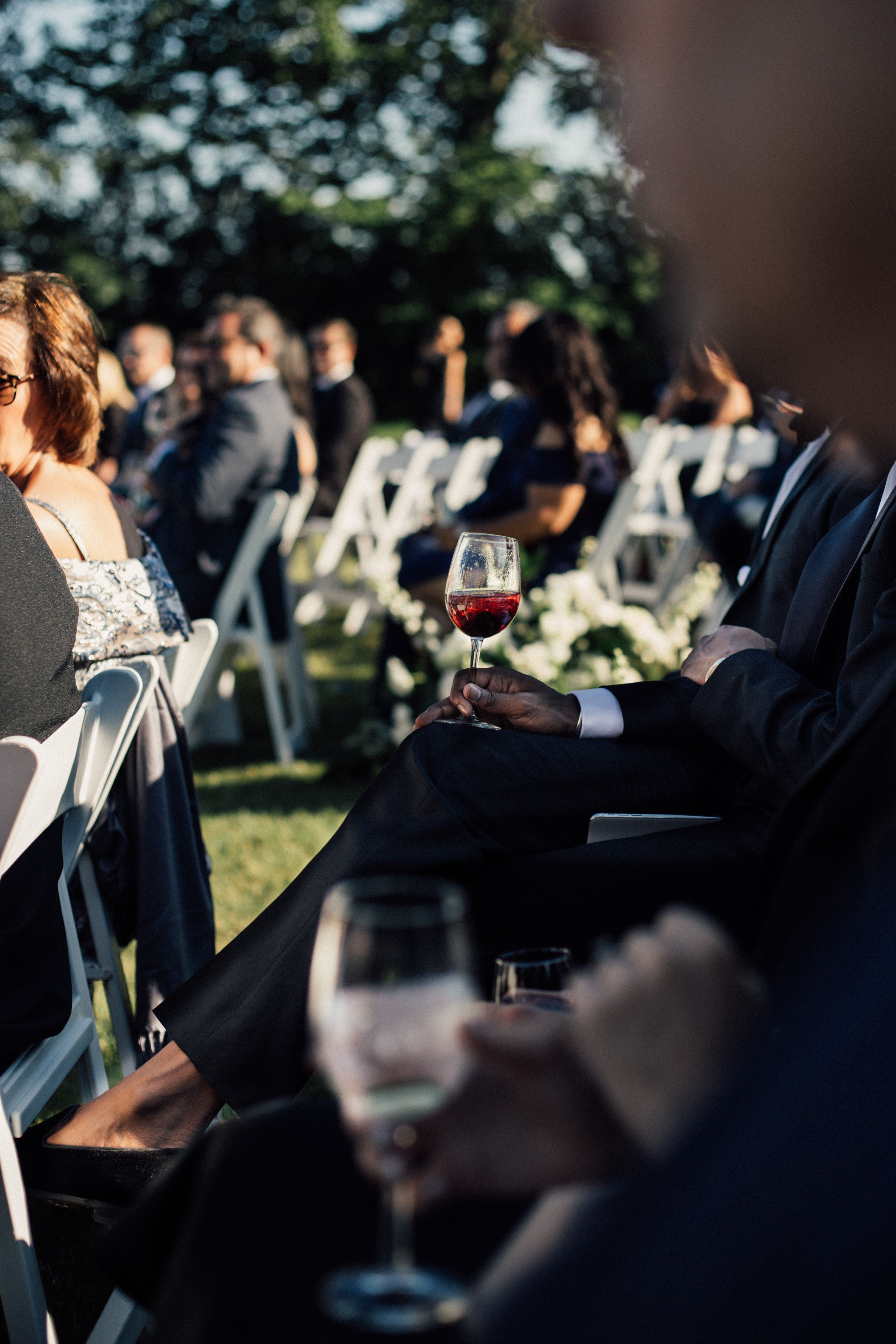 Convidados sentados em cerimônia de casamento ao ar livre, em jardim