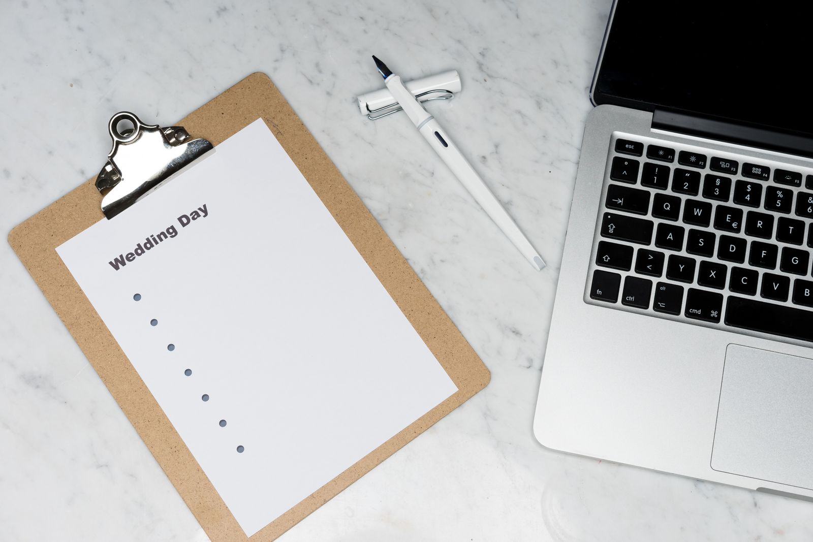 Prancheta com checklist de planejamento de evento ao lado de um notebook, representando os critérios para escolher um aplicativo de confirmação de presença
