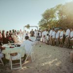 Convidados reunidos em casamento na praia, representando um casamento no exterior