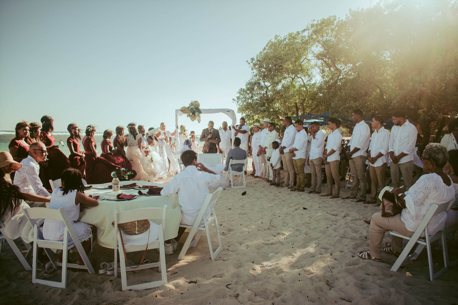 Convidados reunidos em casamento na praia, representando um casamento no exterior